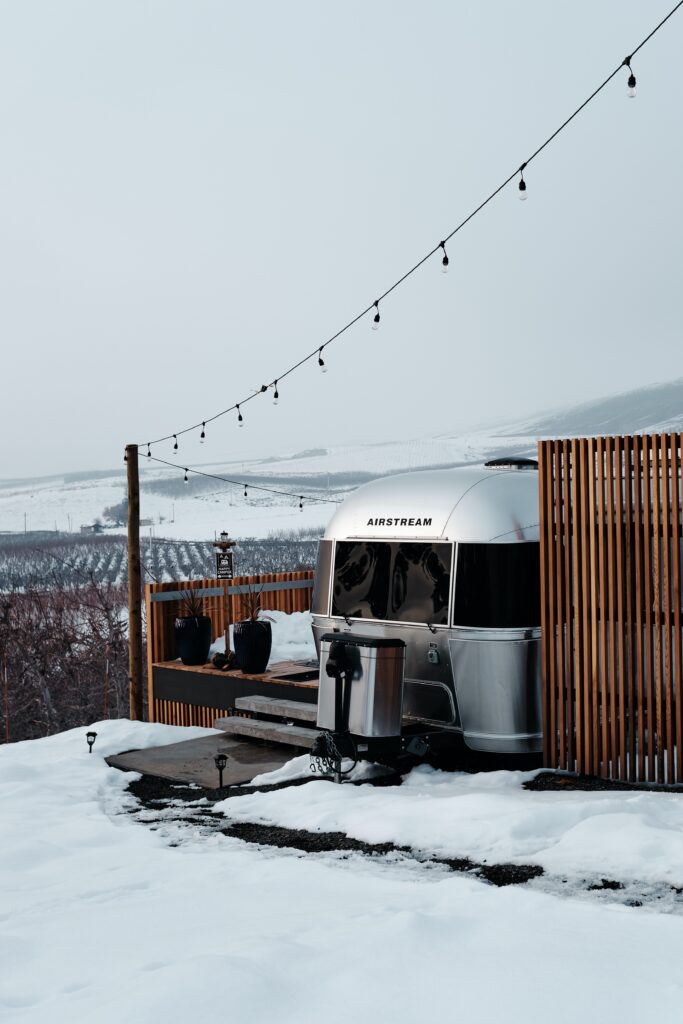 Airstream trailer parked in driveway surrounded by snow Photo by <a href="https://unsplash.com/@nearlywinter?utm_content=creditCopyText&utm_medium=referral&utm_source=unsplash">Zane Lindsay</a> on <a href="https://unsplash.com/photos/IRjAI5XZMks?utm_content=creditCopyText&utm_medium=referral&utm_source=unsplash">Unsplash</a> 
